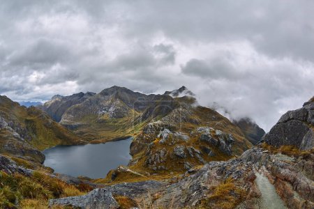 Paysage de haute montagne sur la piste de Routeburn, Grand sentier de randonnée pédestre en Nouvelle-Zélande Île du Sud, temps nuageux, falaises, lac et nuages