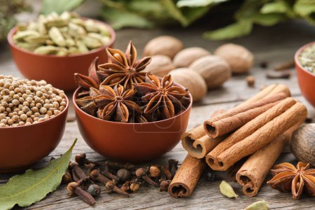 Photo for Bowls of aromatic spices - anise, coriander, cardamom pods. Gloves, cinnamon sticks, nutmegs, laurel leaves. Ingredients for healthy cooking. Ayurvedic remedies. - Royalty Free Image