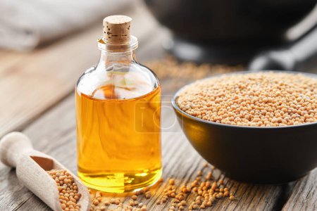 Photo for Bottle of natural organic mustard oil and bowl of whole grain mustard. - Royalty Free Image