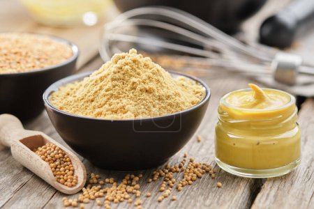 Photo for Mustard sauce jar and bowl of powdered mustard seeds. Scoop of whole mustard grain. - Royalty Free Image