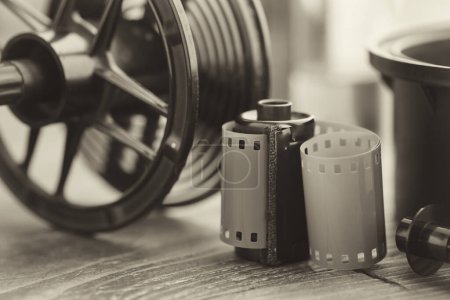 Photo for Photo film roll and cassette, photographic equipment - developing tank with its film reels on background. Selective focus. Retro black and white photo. - Royalty Free Image