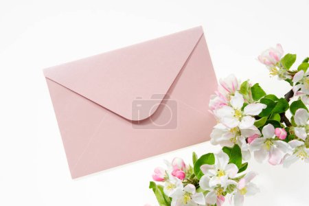 Photo for Pink envelope with wedding invitation card or birthday letter decorated with branch of blossom apple tree. Flat lay. Top view. - Royalty Free Image