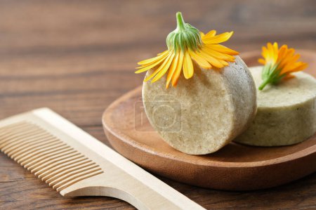 Photo for Natural organic calendula solid shampoo pieces, calendula flower and wooden hair comb. Selective focus. - Royalty Free Image