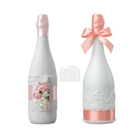Téléchargez les photos : Deux bouteilles de champagne de mariage décorées de fleurs roses, dentelle et ruban. Isolé sur blanc. - en image libre de droit
