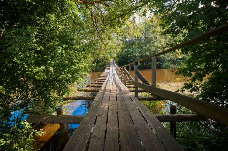 Foto de Puente colgante de madera. Puente peatonal colgante sobre el río Naroch entre los pueblos Ruchitsa y Krasnica. Vileika, región de Minsk, Bielorrusia. - Imagen libre de derechos