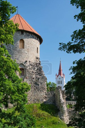 Foto de Atracción turística letona - torre y ruinas del castillo medieval de Cesis Livonian y la iglesia de San Juan en el fondo. Cesis, Letonia. - Imagen libre de derechos