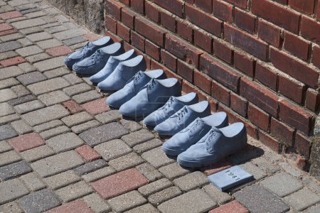 Foto de Cesis, Letonia, 17 de julio de 2023: fila de zapatos en las calles de Cesis en memoria de las víctimas del genocidio del pueblo judío. Cesis, Letonia. - Imagen libre de derechos