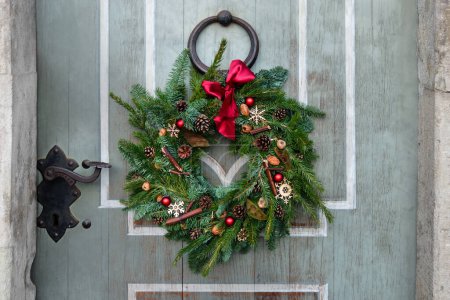 Foto de Corona de Navidad de abeto natural en la puerta vintage. - Imagen libre de derechos