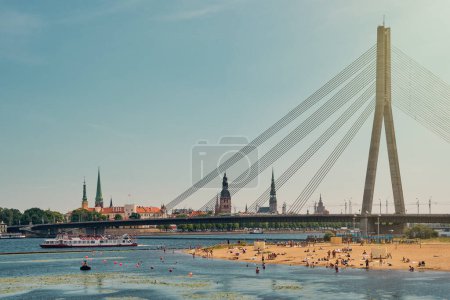 Foto de Vista de la playa sobre el río Daugava y el casco antiguo de Riga, castillo de Riga y puente sobre el río Daugava en la ciudad de Riga, Letonia. - Imagen libre de derechos
