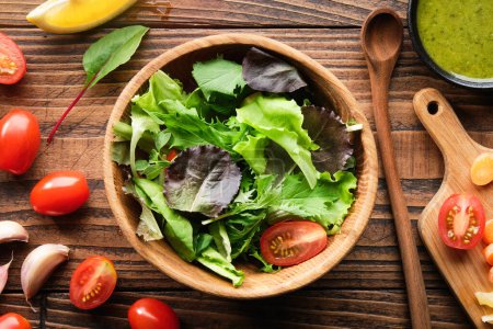 Téléchargez les photos : Salade de légumes dans un bol et ingrédients sur une table en bois. Vue de dessus, plan plat. - en image libre de droit