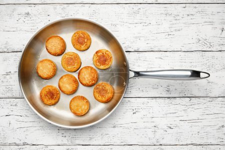 Photo for Cottage cheese pancakes. Syrniki in a frying pan. Cheesecakes, top view, flat lay. - Royalty Free Image