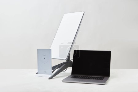 Photo for KYIV, UKRAINE - JANUARY 24, 2023: Starlink antenna, wi-fi router and laptop on white surface. Home office concept. - Royalty Free Image