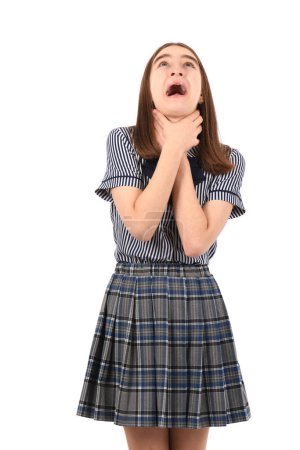 Young beautiful girl in a school uniform on a white background, shouting and suffocate because painful strangle. Health problem. Asphyxiate and suicide concept.