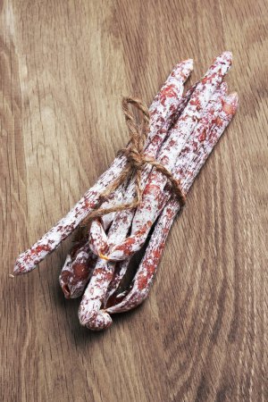 Photo for Salami sausages on a wooden background - Royalty Free Image