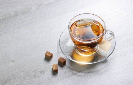 Photo for Cup of Tea and teabag, sugar, on a light wooden background - Royalty Free Image
