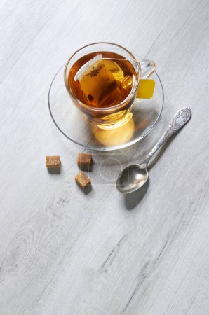 Foto de Taza de té y té, cuchara, azúcar, sobre un fondo de madera clara - Imagen libre de derechos