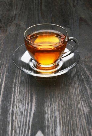 Téléchargez les photos : Tasse de thé sur un fond de bois sombre - en image libre de droit