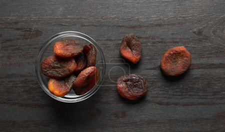 Téléchargez les photos : Abricots secs sur fond de bois - en image libre de droit