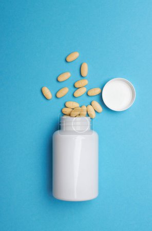 Photo for Pills with bottle on a blue background - Royalty Free Image