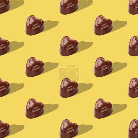 Téléchargez les photos : Bonbons au chocolat sur fond jaune. Vue de dessus. Pop art design. Style de pose minimal plat. - en image libre de droit