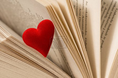 Close-up view of red heart on the open book pages. Concept of Valentine's day, love, love reading.