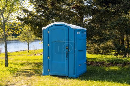 Vorübergehende blaue tragbare Plastiktoilette in einem Sommerpark