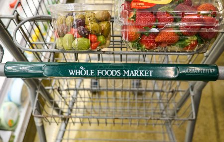Photo for Dallas TX, USA - February 25, 2024: Cart of Whole Foods Market with groceries. Owned by Amazon, Whole Foods a US grocery chain sells food free of artificial ingredients and unhealthy fats. - Royalty Free Image
