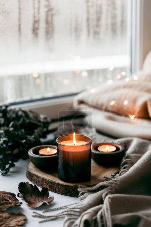 warme, gemütliche Fenstergestaltung, Winter- oder Herbstkonzept, Kerzen werfen Lichter