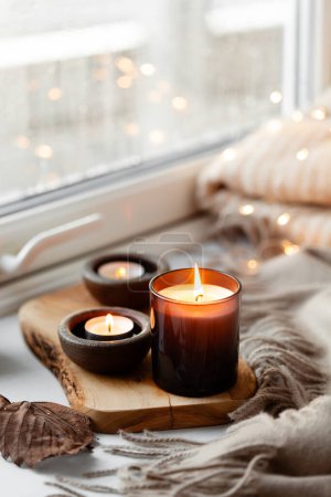  warme, gemütliche Fenstergestaltung, Winter- oder Herbstkonzept, Kerzen werfen Lichter 