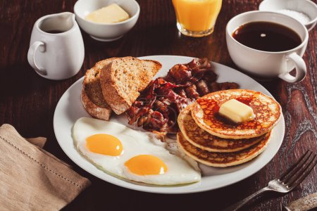 Photo for Traditional full american breakfast eggs pancakes with bacon and toast - Royalty Free Image