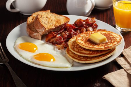 Téléchargez les photos : Traditionnel petit déjeuner américain œufs crêpes avec bacon et pain grillé - en image libre de droit