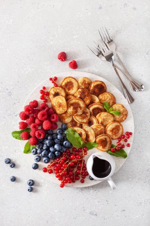 amerikanisches Mini-Pfannkuchenbrett mit Beeren und Ahornsirup