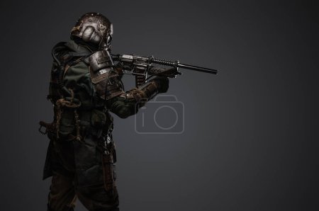 Photo for Portrait of military man in post apocalypse style dressed in armored suit aiming shotgun. - Royalty Free Image