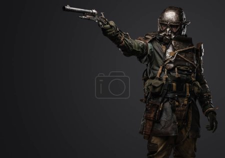 Photo for Shot of isolated on grey background soldier in setting of post apocalypse aiming pistol. - Royalty Free Image