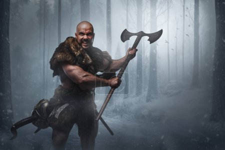 Téléchargez les photos : Portrait de guerrier scandinave agressif avec hache à fourrure en bois givré. - en image libre de droit