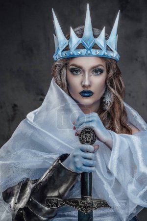 Portrait of ice queen with crown and colden skin holding sword.