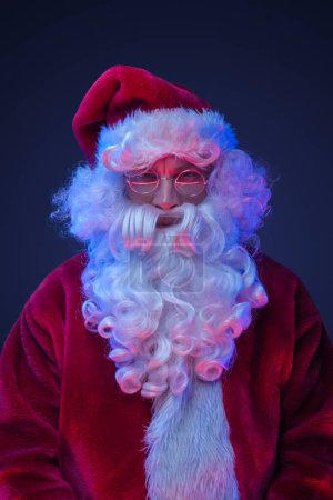Photo for Studio shot of elderly santa claus dressed in red clothes and hat. - Royalty Free Image