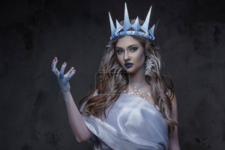 Foto de Estudio de la princesa de hielo vestido con capa y corona sobre fondo oscuro. - Imagen libre de derechos