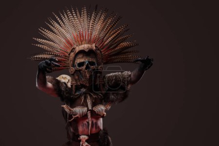 Téléchargez les photos : Prise de vue de zombie effrayante femme vêtue de vêtements autochtones sombres et coiffure de cérémonie. - en image libre de droit