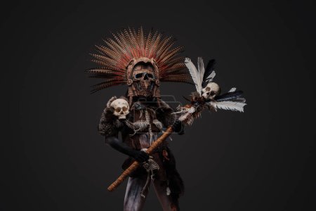 Téléchargez les photos : Plan studio de sorcière aztèque effrayante vêtue de vêtements autochtones avec coiffure à plumes. - en image libre de droit