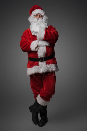 Téléchargez les photos : Tournage de Père Noël barbu avec costume d'hiver rouge regardant la caméra. - en image libre de droit