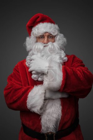 Photo for Shot of bearded santa with red winter costume looking at camera. - Royalty Free Image