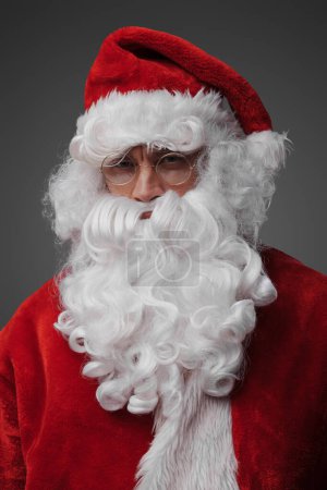 Photo for Portrait of santa claus with beard and red costume against grey background. - Royalty Free Image