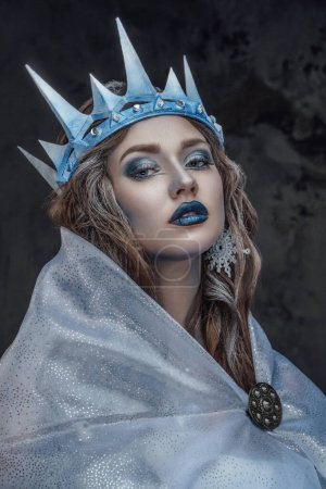 Foto de Retrato de atractiva doncella de hielo con maquillaje y capa mirando a la cámara. - Imagen libre de derechos