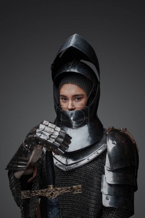 Photo for Shot of knight woman with sword dressed in chainmail and helmet. - Royalty Free Image
