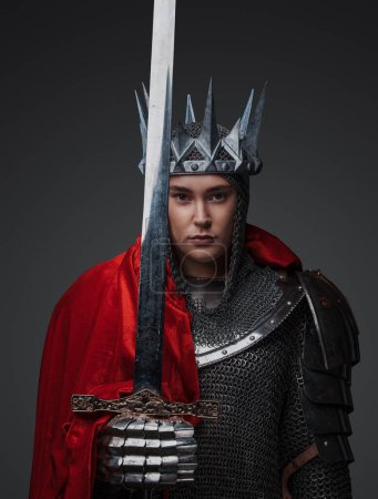 Téléchargez les photos : Photo de courageuse reine médiévale vêtue d'armure et couronne tenant épée. - en image libre de droit