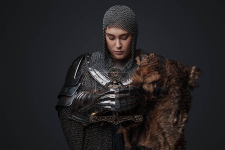 Téléchargez les photos : Portrait de chevalier femme vêtue d'armure et de maille sur fond gris. - en image libre de droit