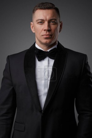 Foto de Retrato de un hombre guapo vestido con un elegante traje negro mirando a la cámara. - Imagen libre de derechos