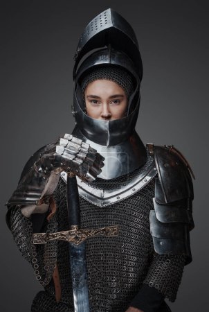 Foto de Foto de caballero mujer con espada vestida con cota de malla y casco. - Imagen libre de derechos
