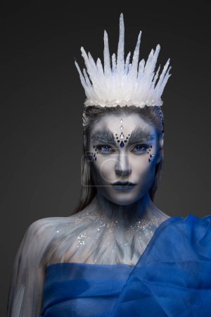 Photo for Studio shot of winter queen with blue cape and ice crown isolated on gray. - Royalty Free Image
